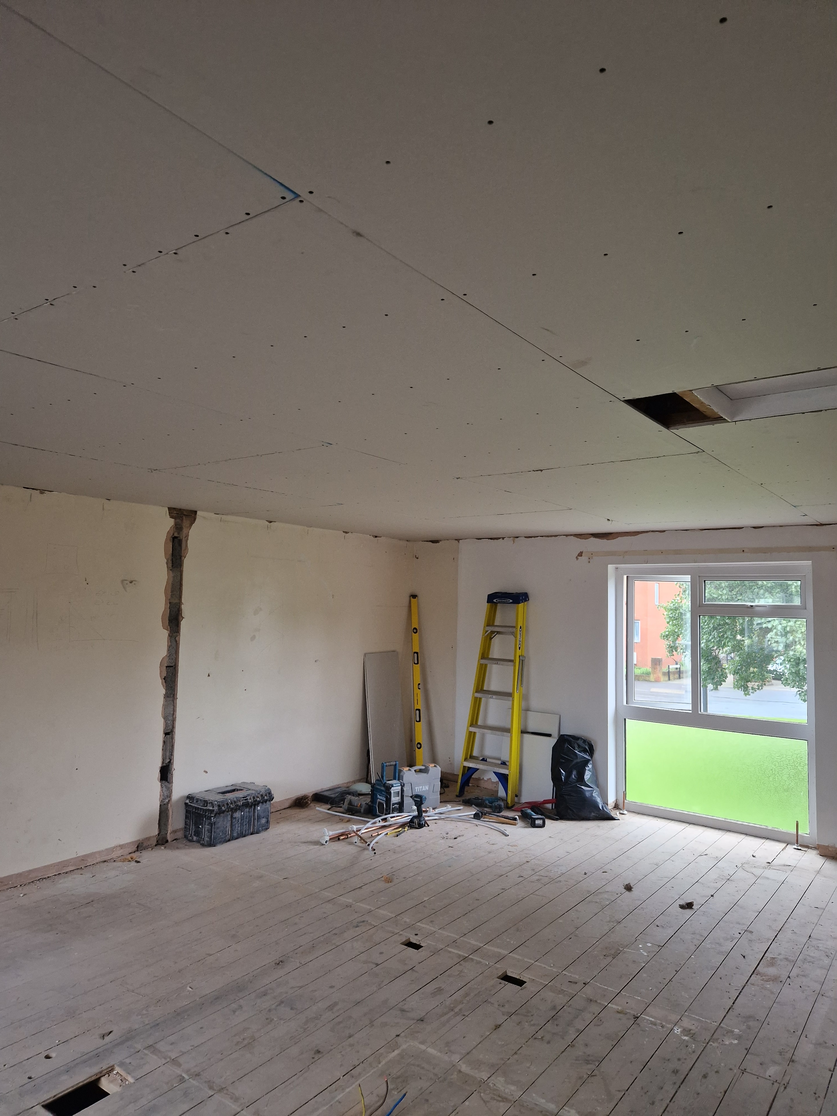 First-floor renovation in progress, with the ceiling boarded and walls being prepared for finishing